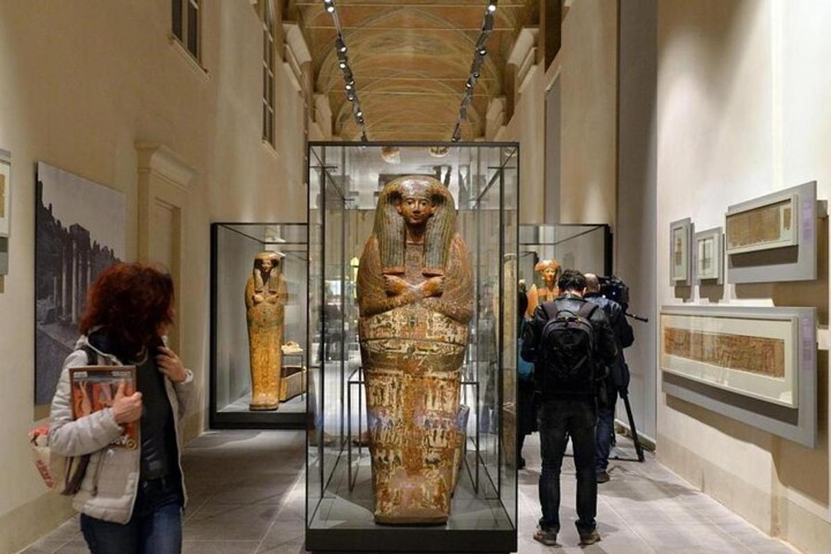 sebuah muzium dengan orang melihat patung dalam bekas kaca
