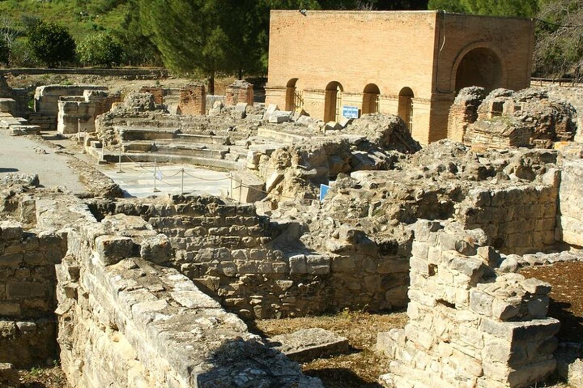 an ancient ruins with a building in the background
