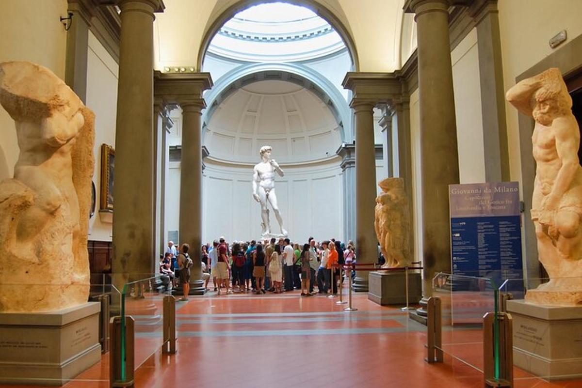eine Gruppe von Menschen, die eine Statue in einem Museum betrachten