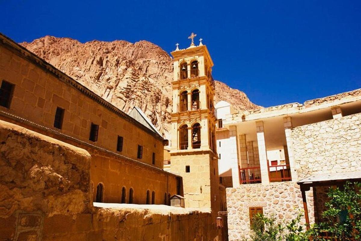 un edificio con una torre dell'orologio di fronte a una montagna