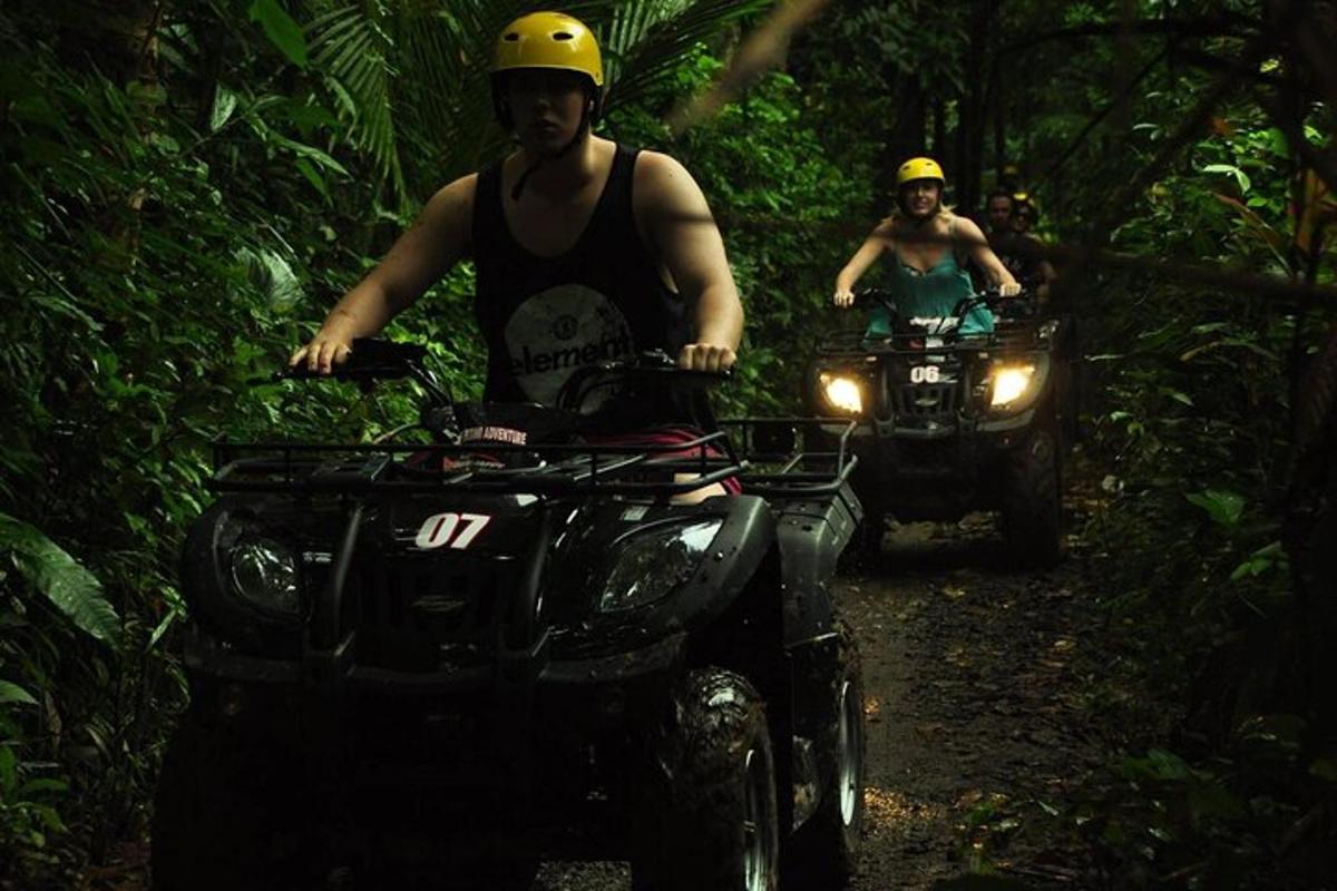 dua orang menunggang atv di laluan di dalam hutan