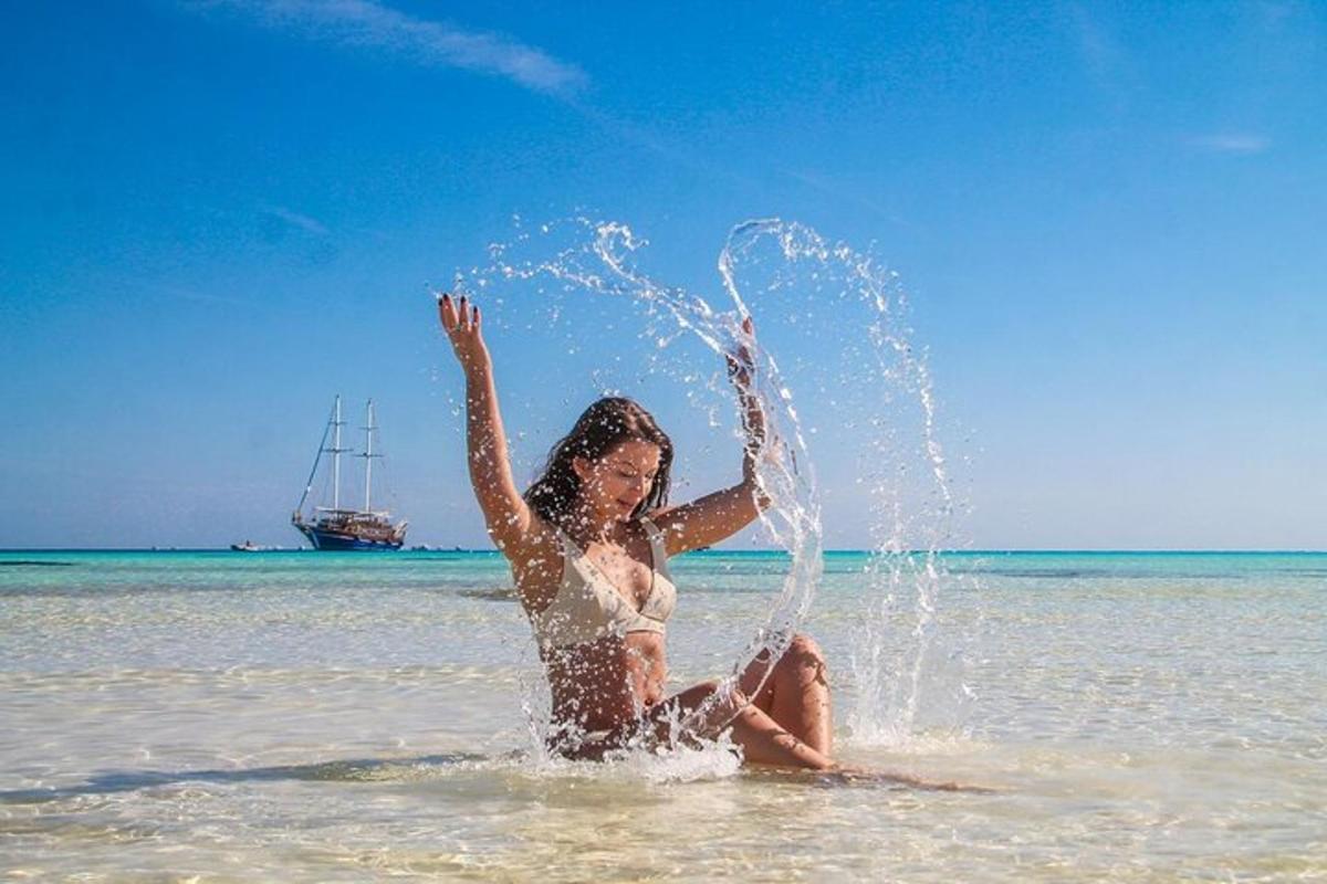 una donna che gioca nell'acqua sulla spiaggia