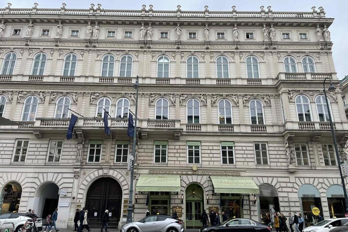 un grande edificio con auto parcheggiate di fronte