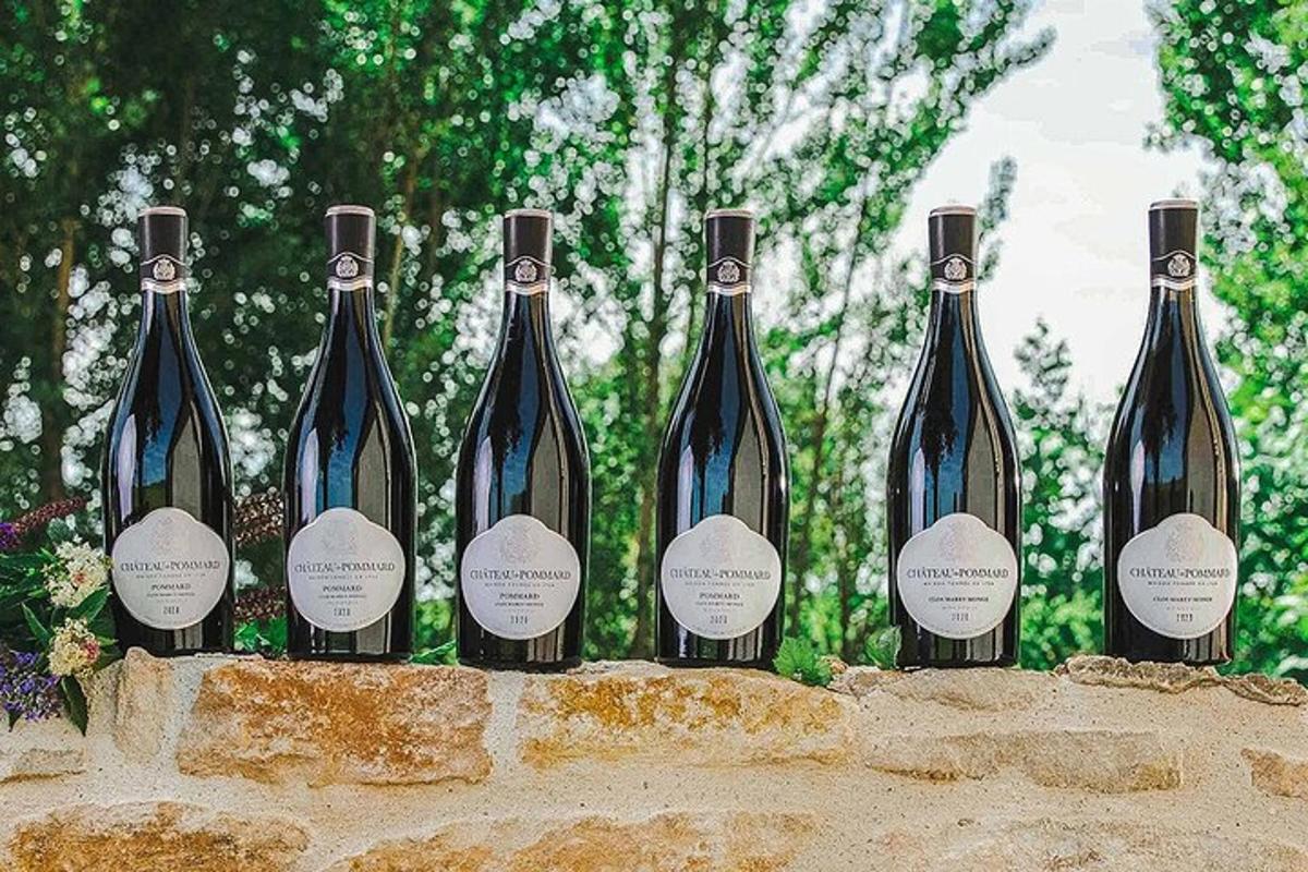 a row of wine bottles sitting on a stone wall
