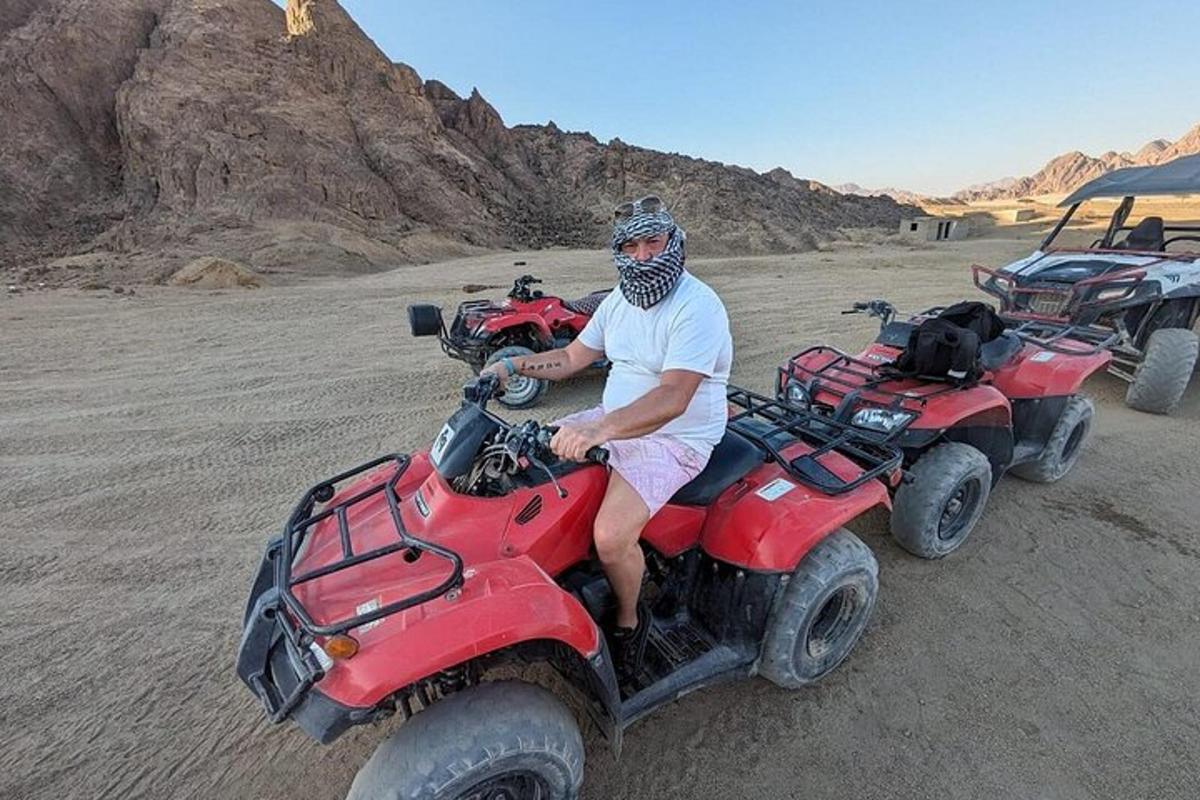 a man sitting on a four wheeler in the desert