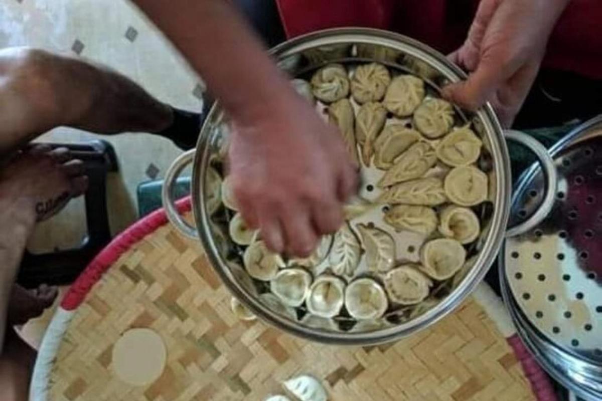 osoba držící misku s jídlem na stole