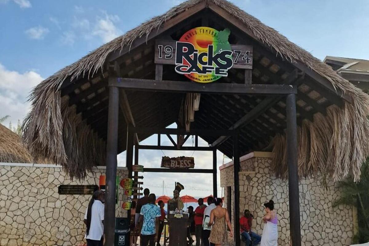 Un restaurante con gente parada afuera de un edificio.