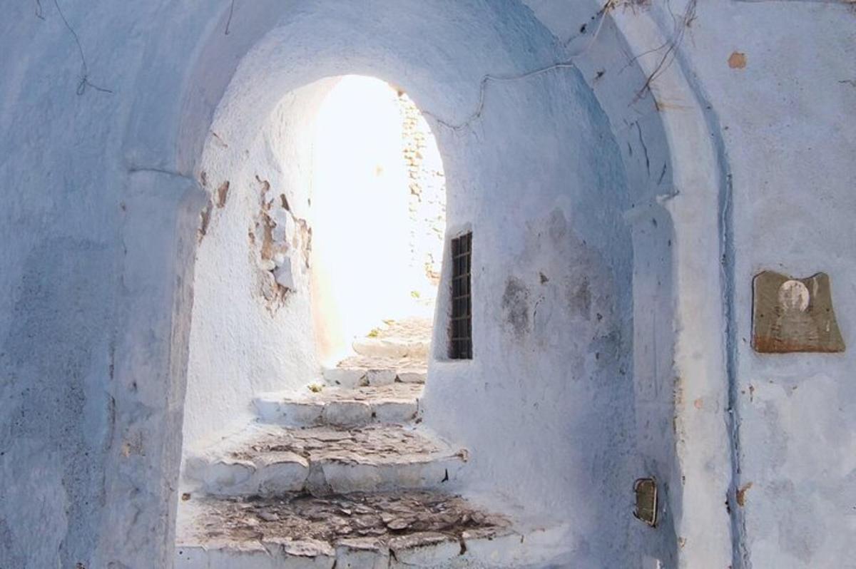 an archway in a white building with stairs