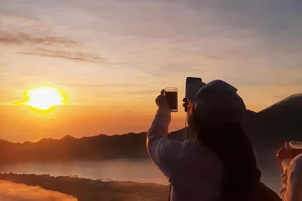 особа која фотографише залазак сунца