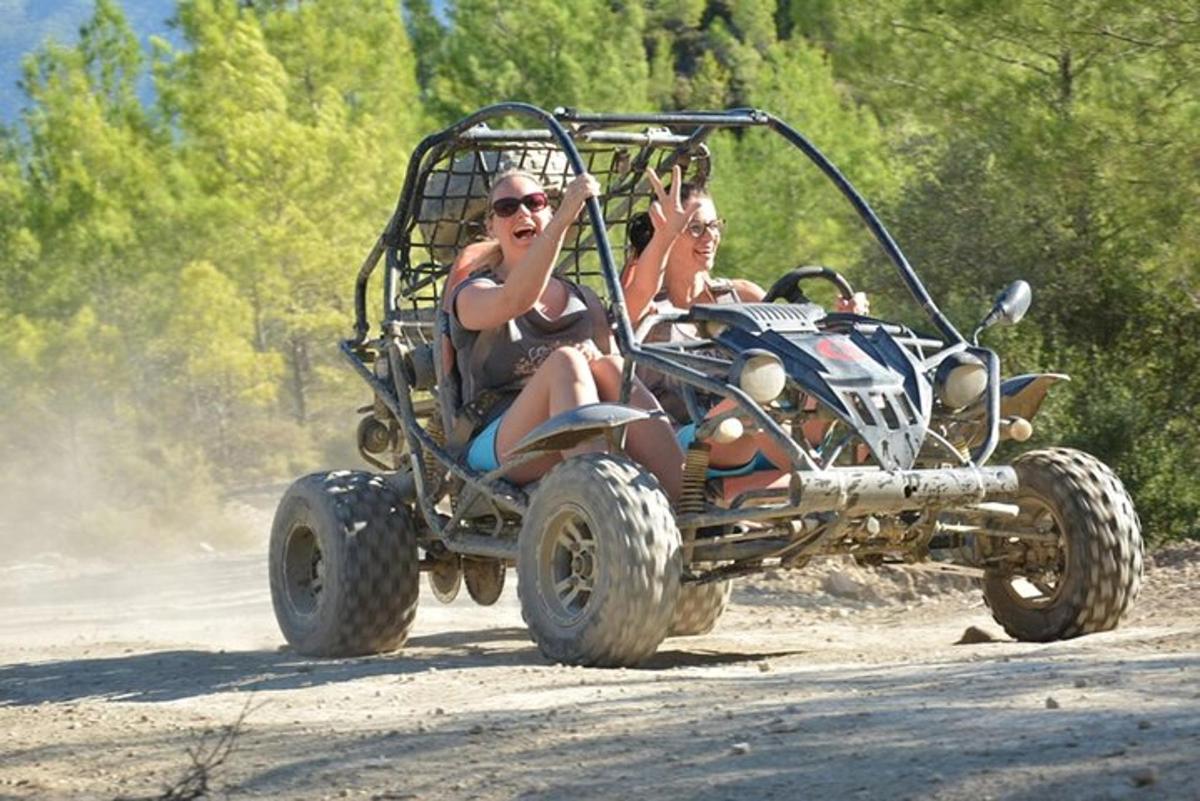 dues persones que viatgen en un quad per una carretera de terra