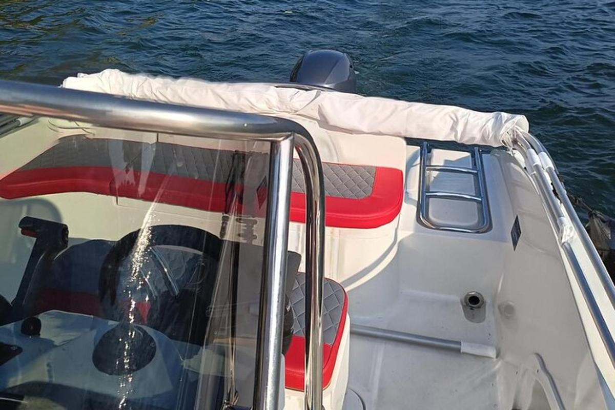 a white boat with a red seat on the water