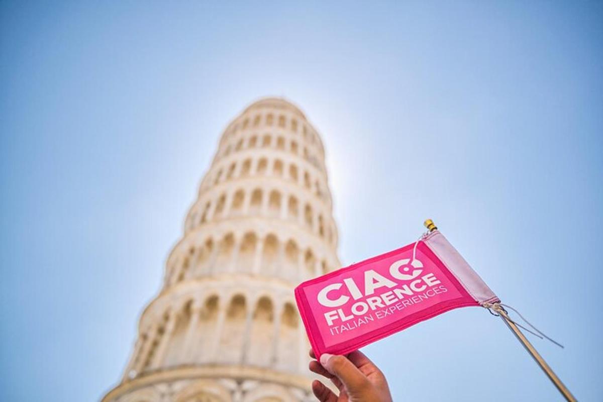 una persona che tiene un cartello rosa davanti alla torre pendente