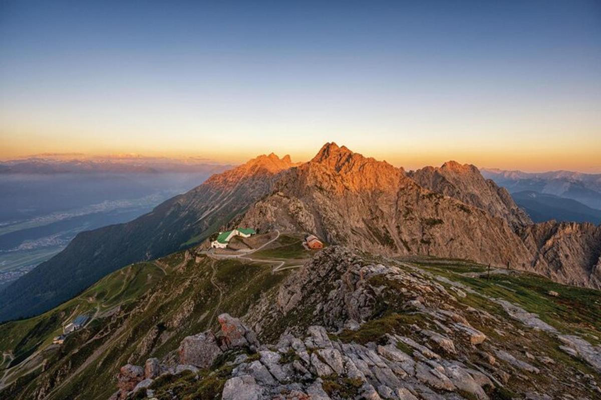 una vista di una montagna con il sole che tramonta su di essa