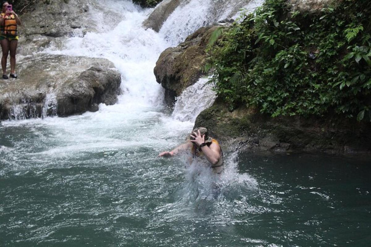 un uomo nell'acqua davanti a una cascata