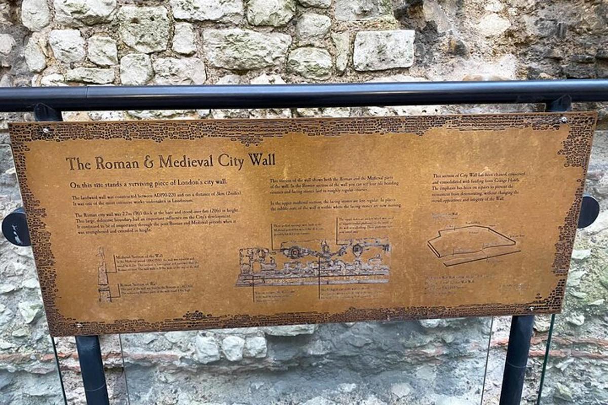 un cartello davanti a un muro di pietra