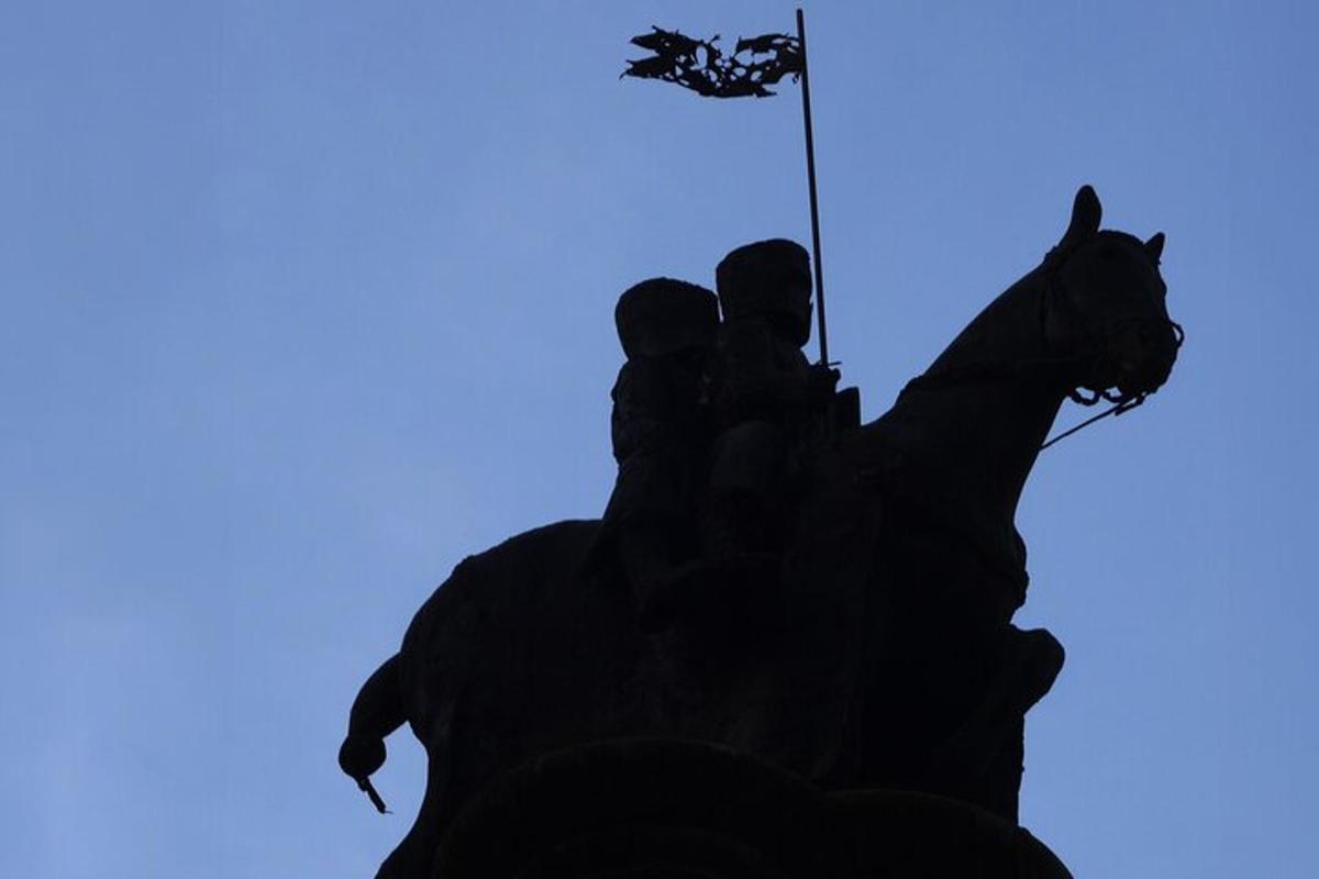 a silhouette of a person riding a horse with a flag