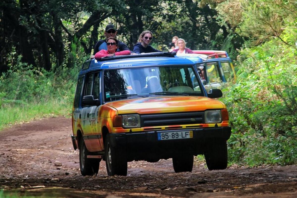 un gruppo di persone che viaggiano sul retro di un veicolo su una strada sterrata