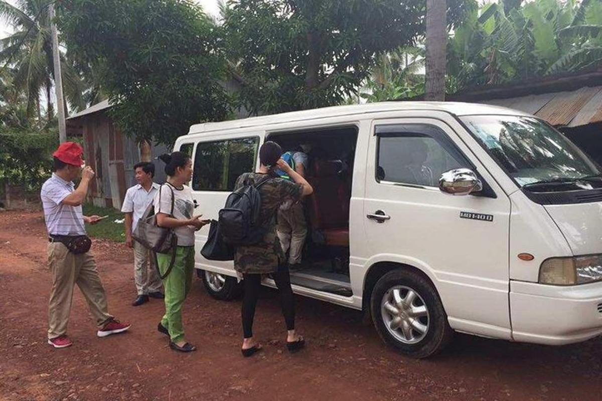 Un grupo de personas paradas afuera de una camioneta blanca