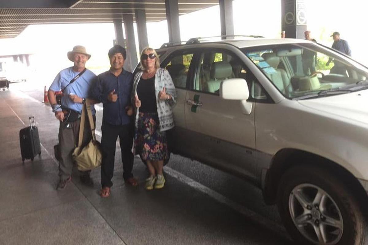 Un grupo de personas de pie junto a un coche.