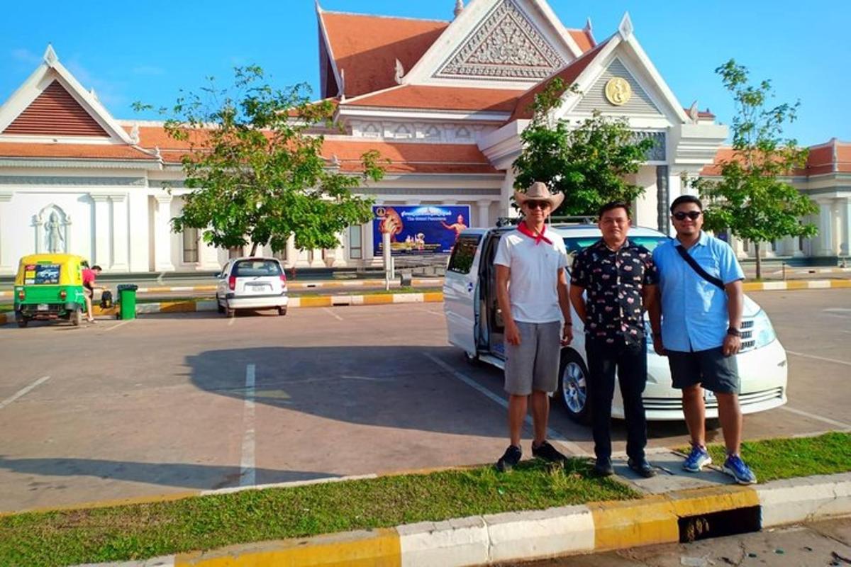 sekelompok tiga pria berdiri di depan mobil
