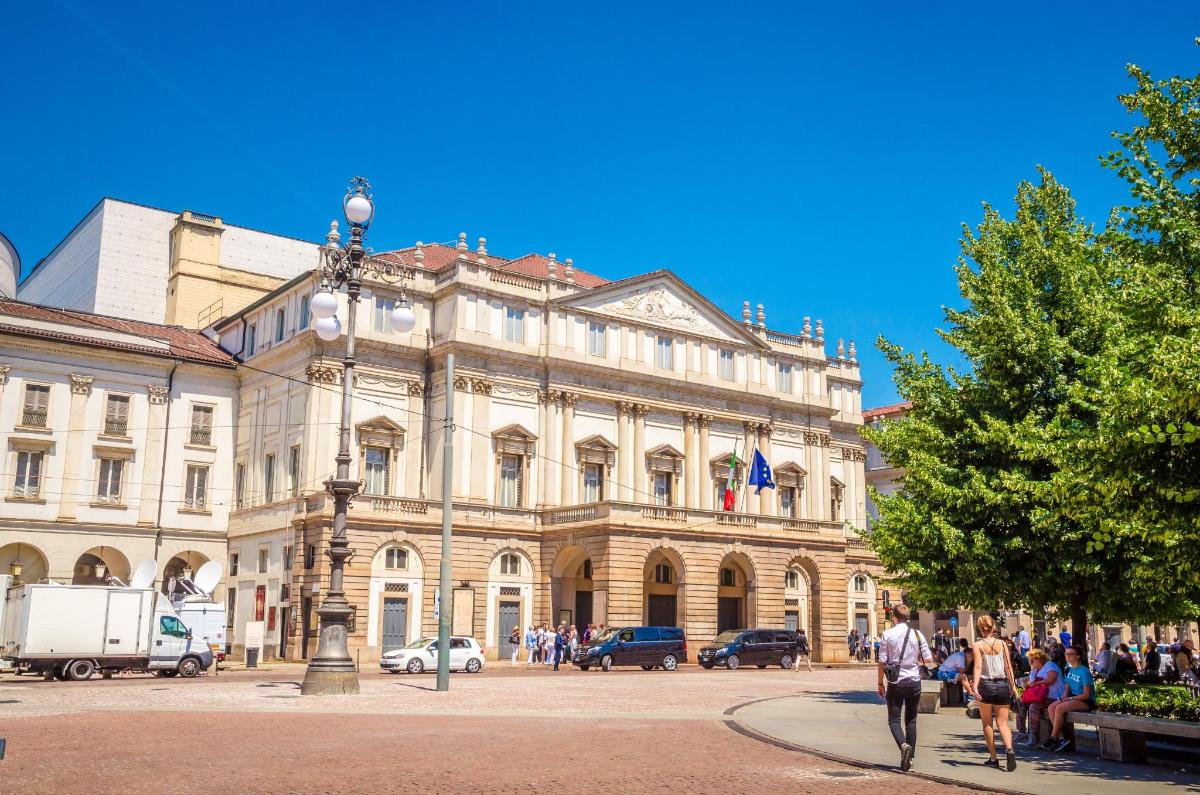 un grande edificio con persone che camminano davanti ad esso
