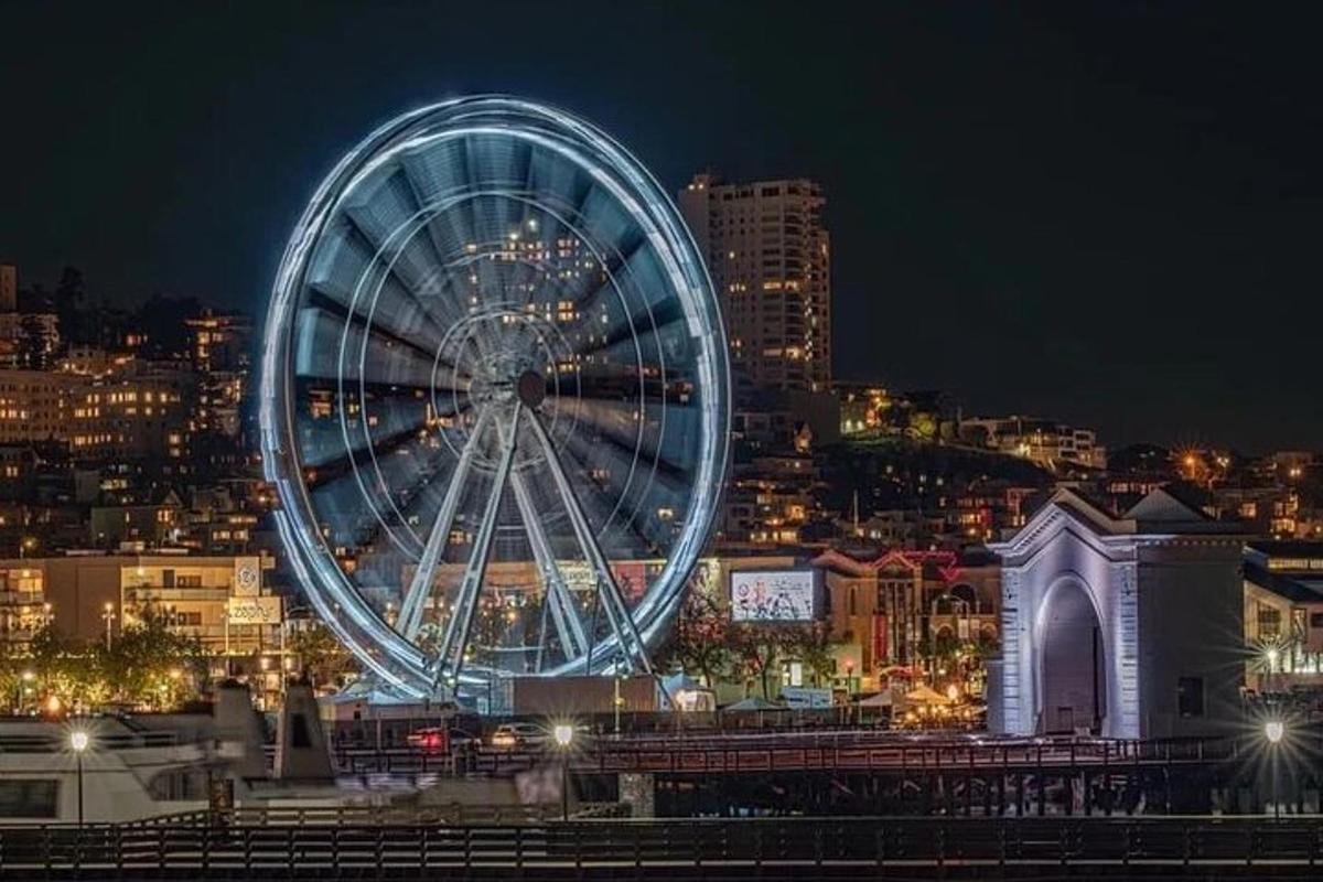 a large ferris wheel in a city at night