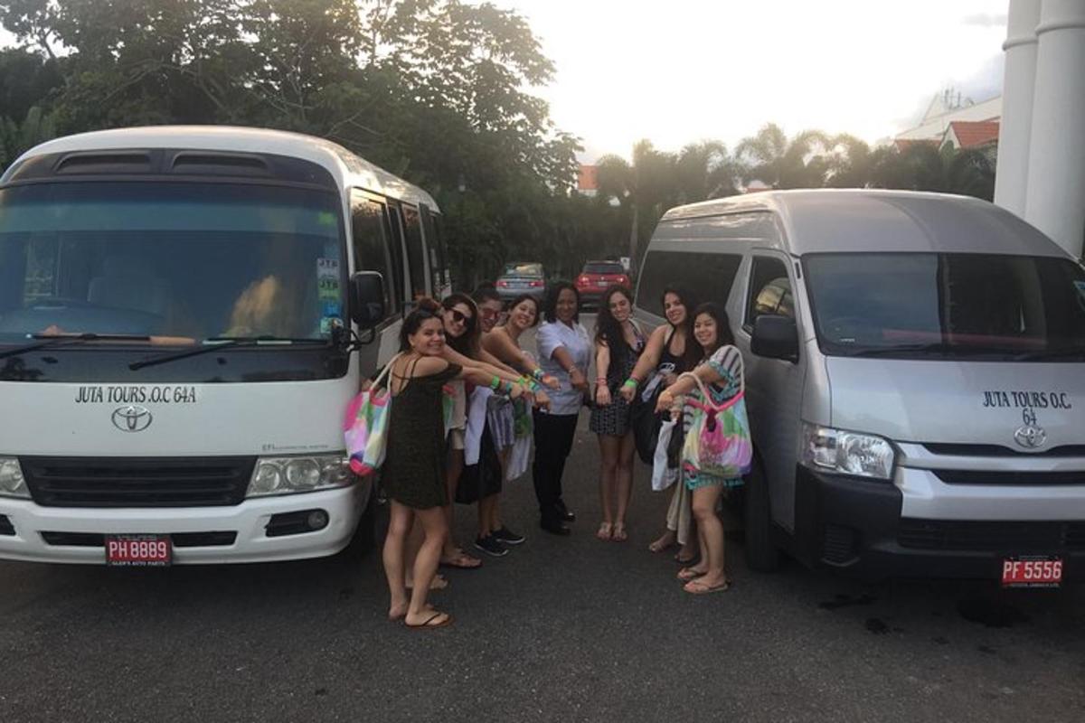 một nhóm người đứng cạnh hai chiếc xe buýt
