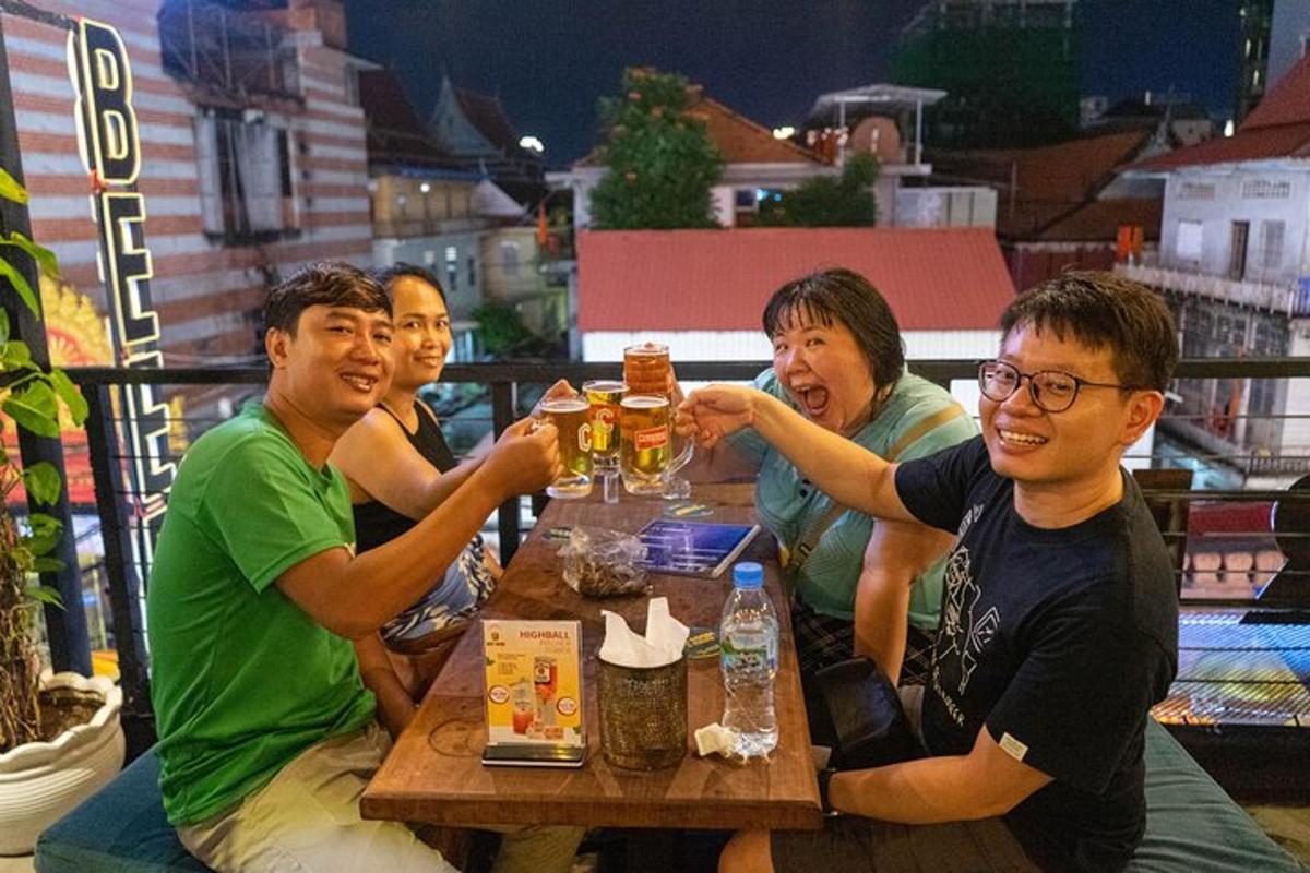 un grup de persones assegudes a una taula bevent cervesa