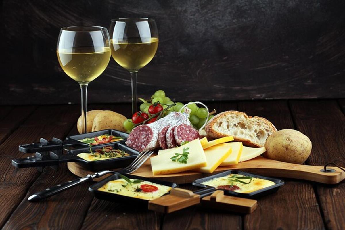 một cái bàn có hai ly rượu vang, phô mai và bánh mì
