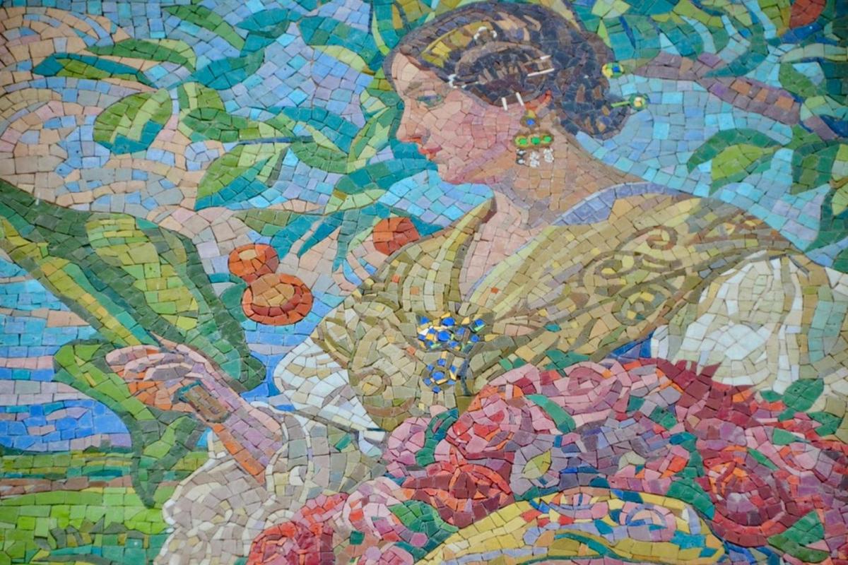 um mural de mosaico de uma mulher com frutas