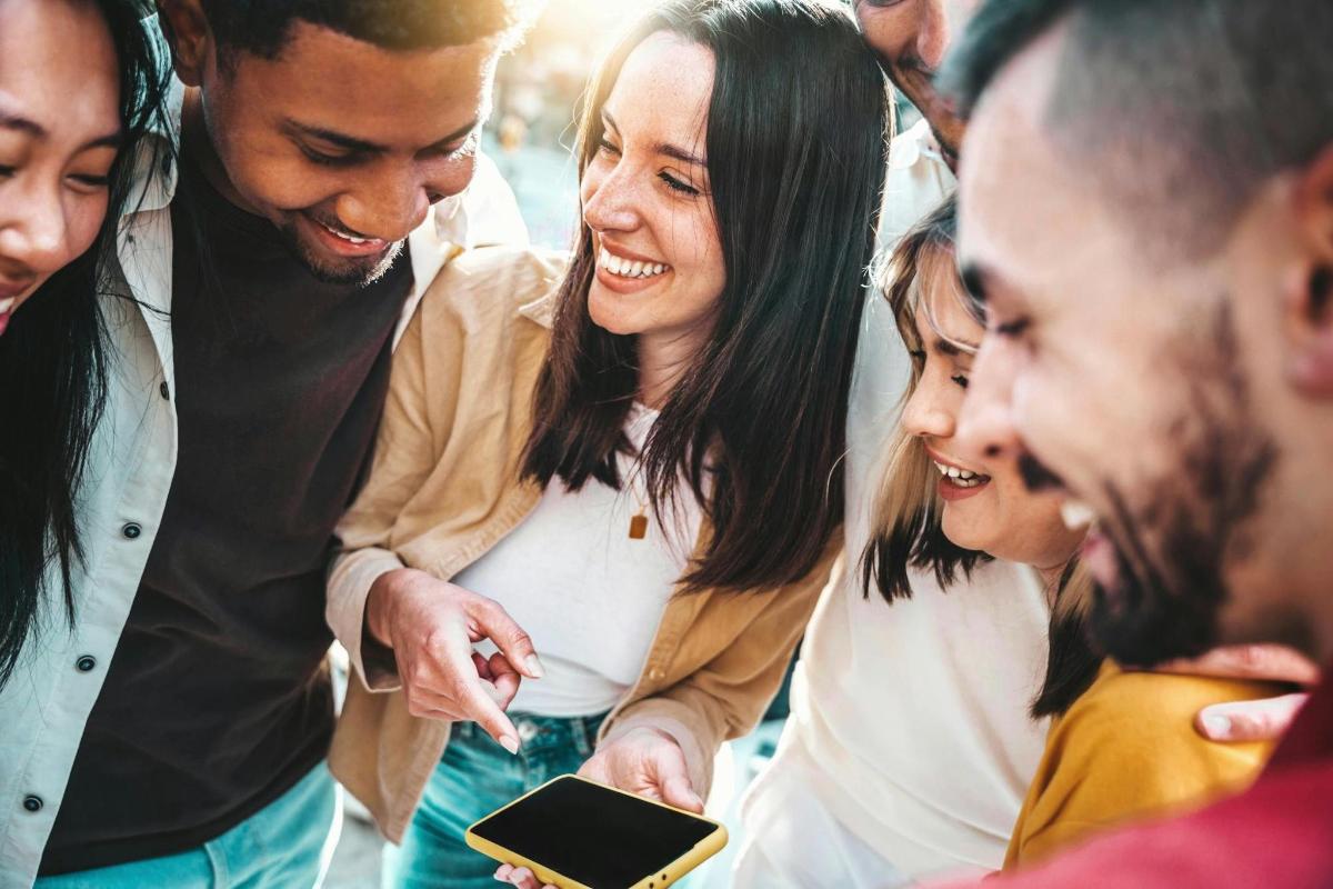 a group of people looking at a cell phone