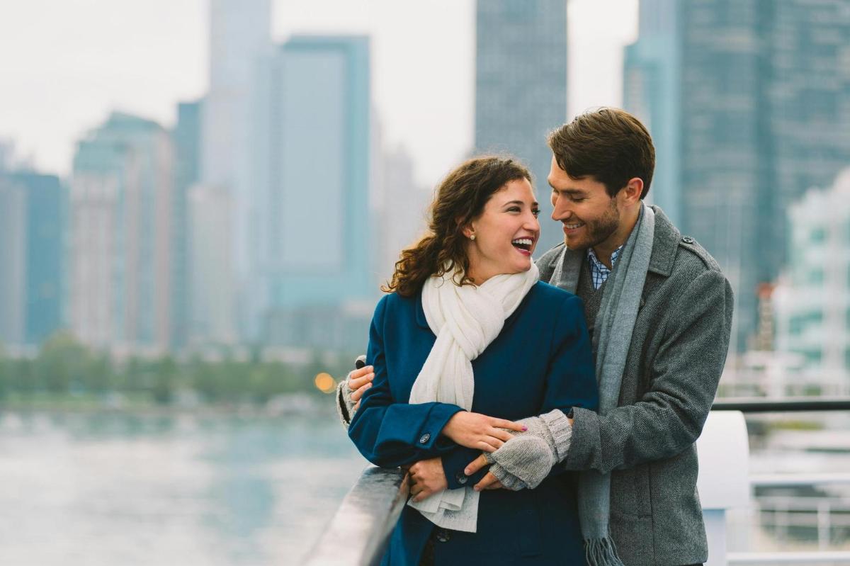 a man and a woman standing in front of a city