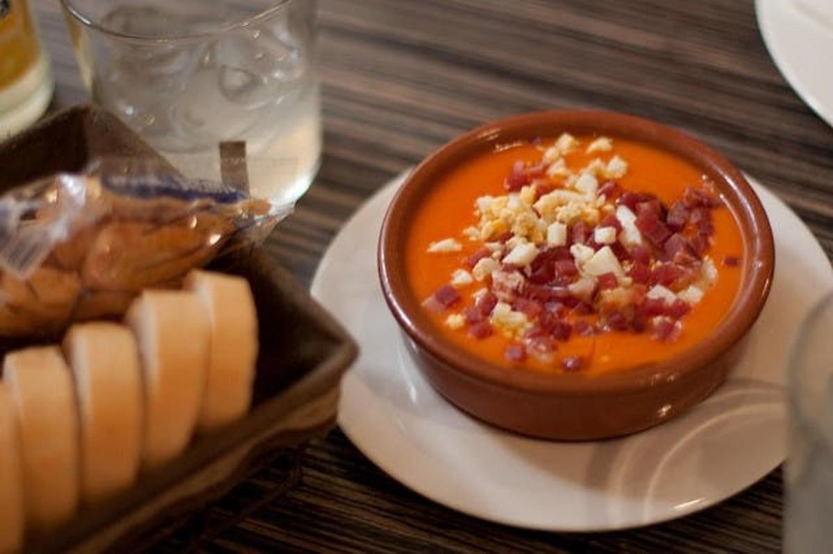 Un plato de comida con un tazón de sopa y pan.