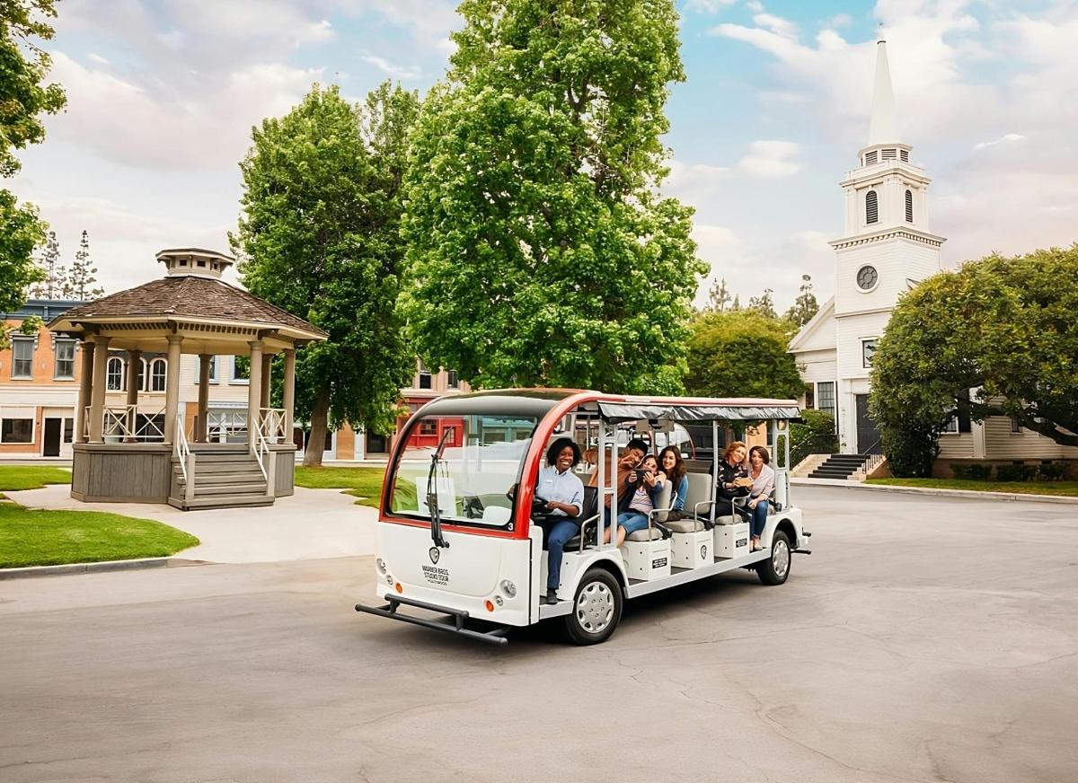 skupina ljudi, ki se vozijo v golfskem vozičku