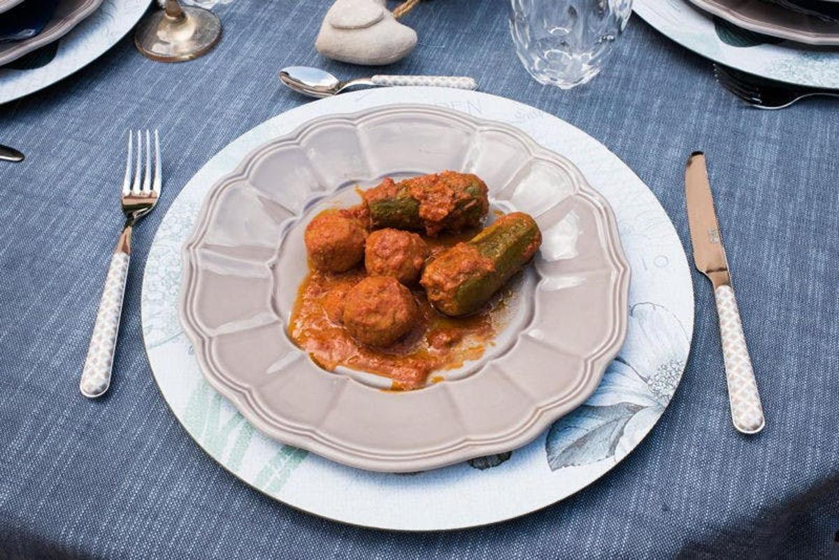 um prato de comida com almôndegas e vegetais sobre uma mesa