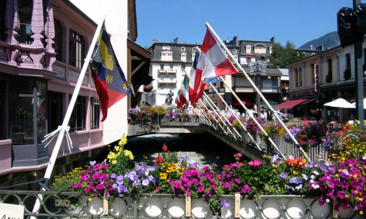 a bridge over a canal with flags and flowers