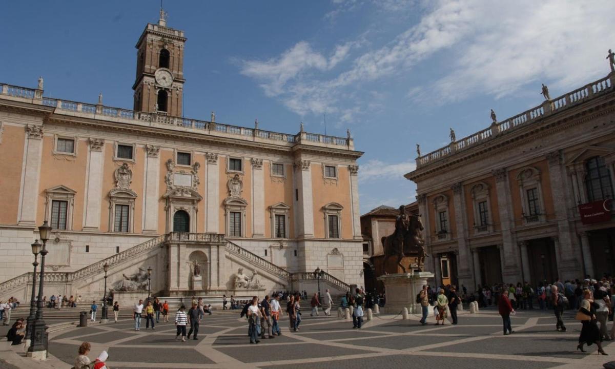 un gruppo di persone che camminano davanti a un edificio con una torre dell'orologio