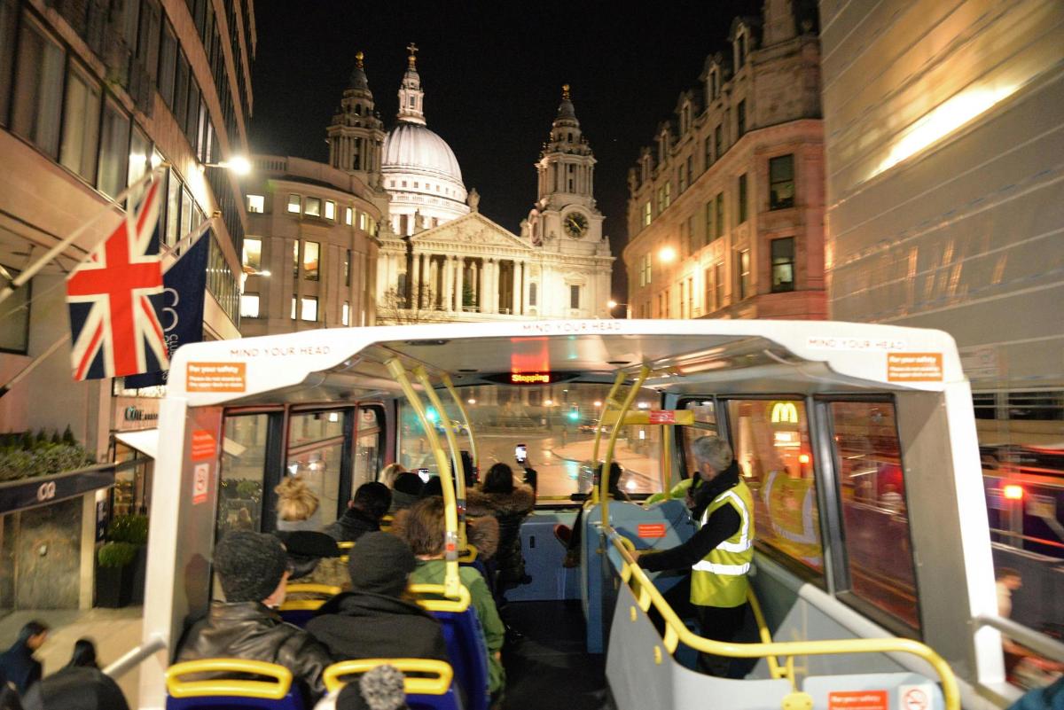 a group of people riding on a tram in front of a building