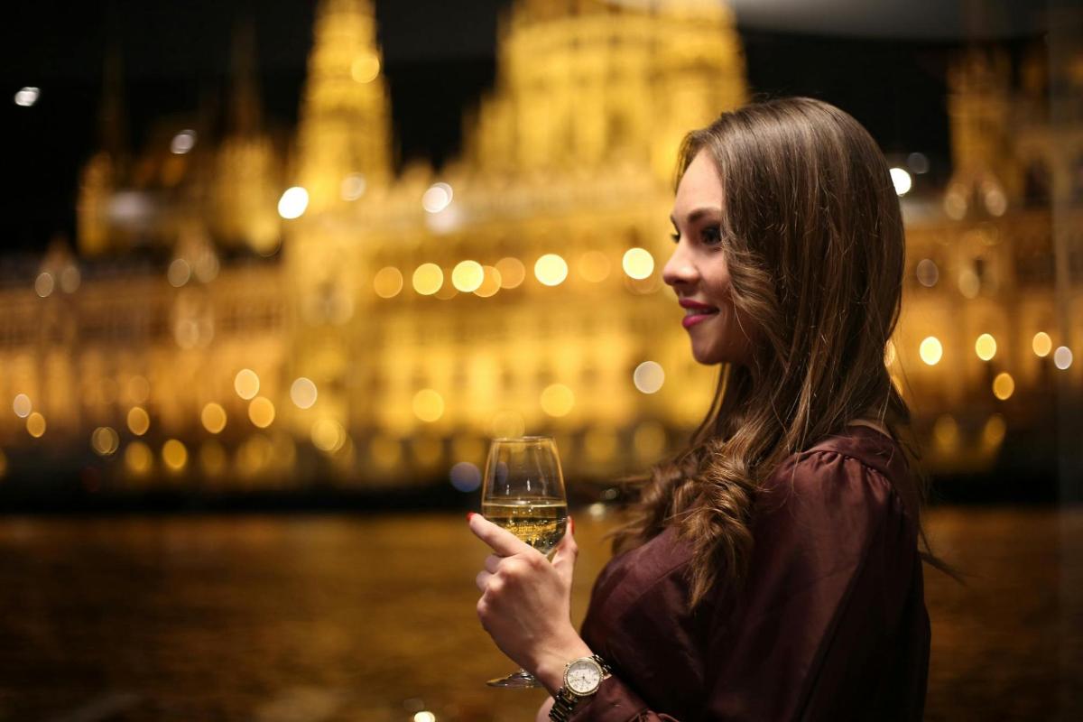 Una mujer sosteniendo una copa de vino por la noche