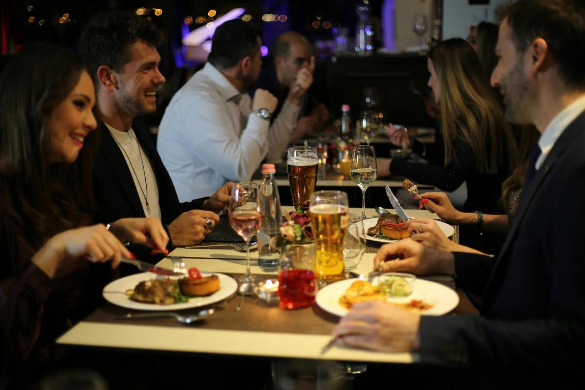 Un grupo de personas sentadas alrededor de una mesa comiendo comida
