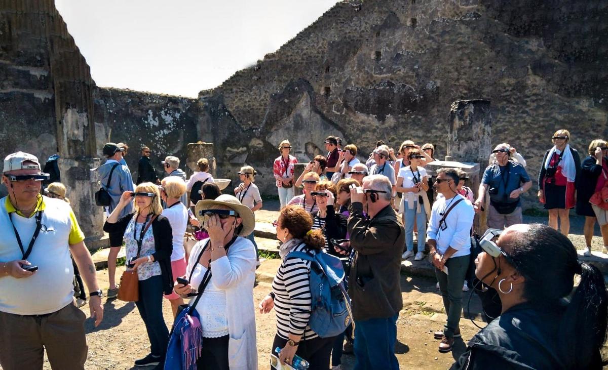 eine große Gruppe von Menschen steht um eine Pyramide herum