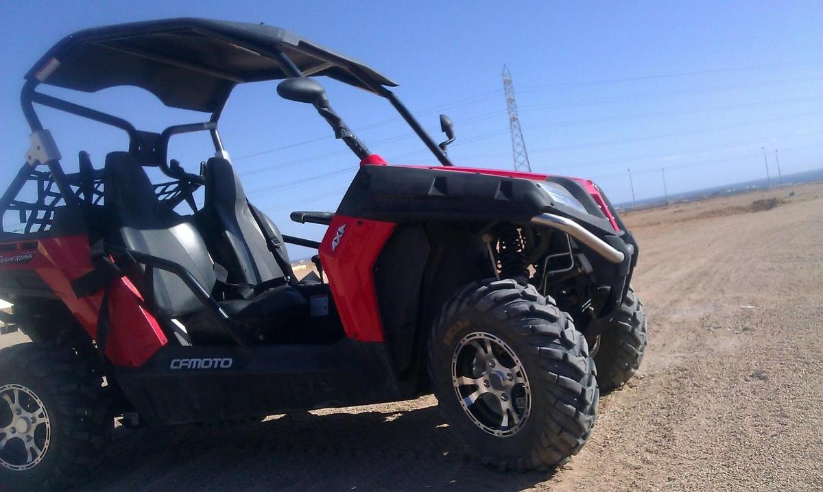 未舗装道路に駐車された赤と黒のATV