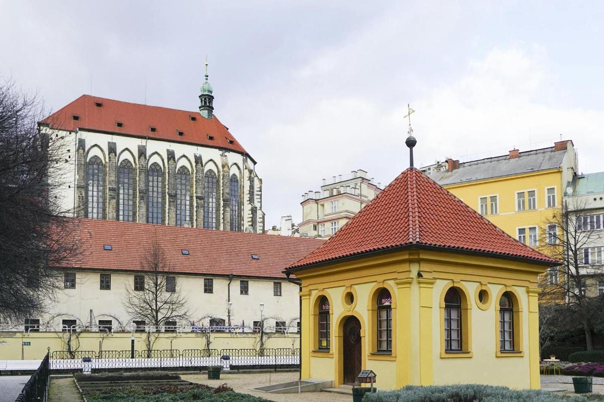 žlutá budova s červenou střechou před budovou