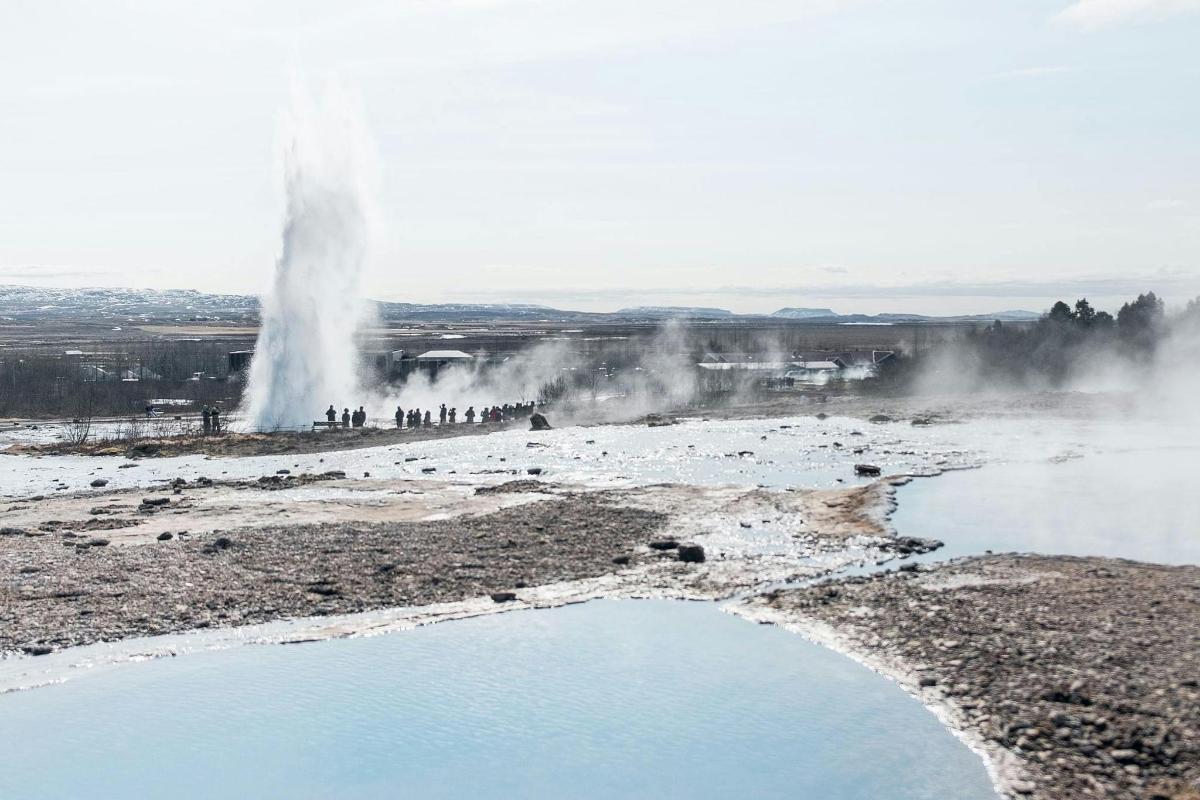 Una vista de un géiser con un charco de agua.