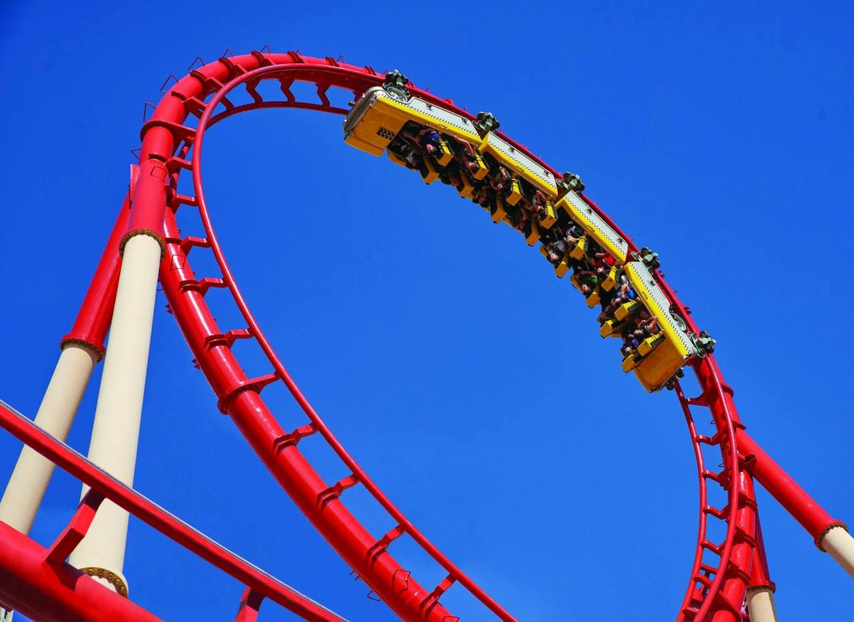 roller coaster merah dengan latar langit biru