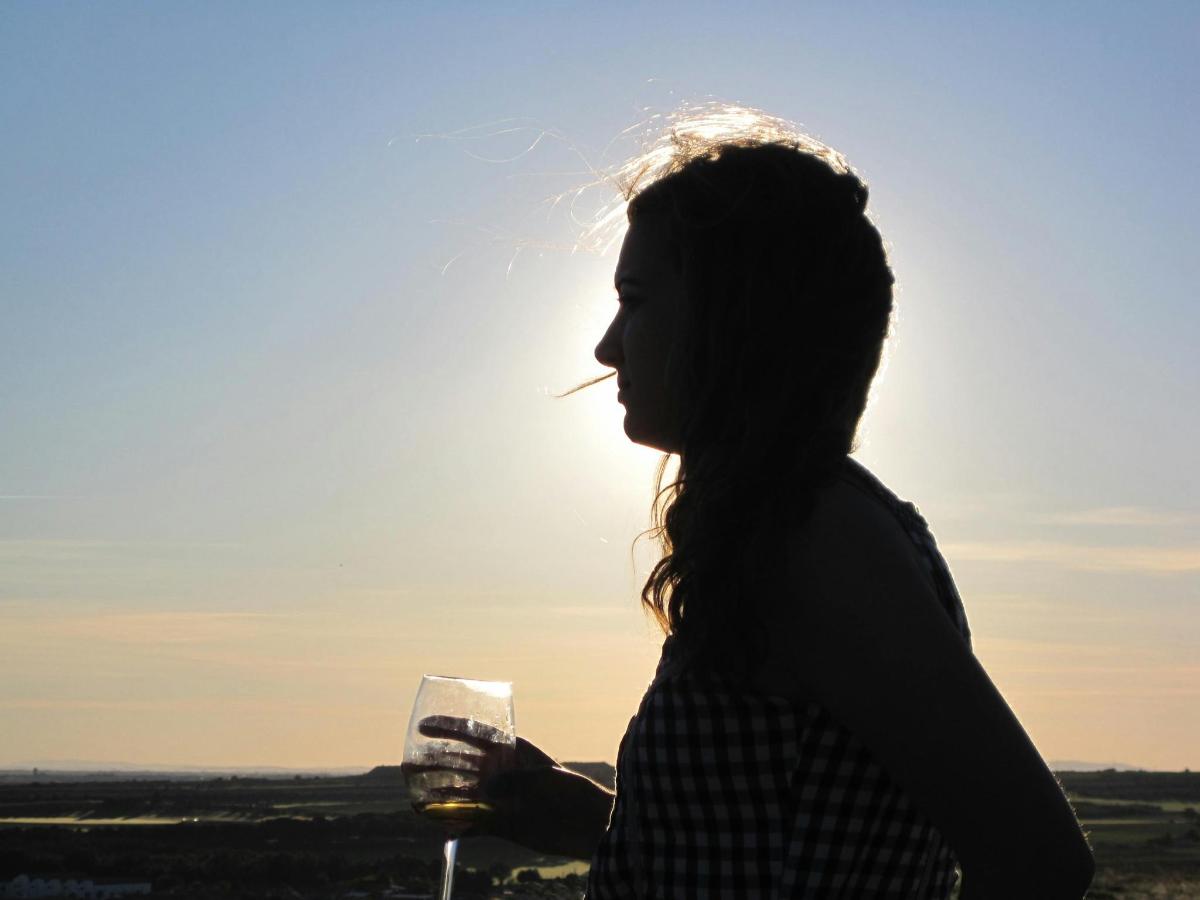 ženska drži kozarec vina