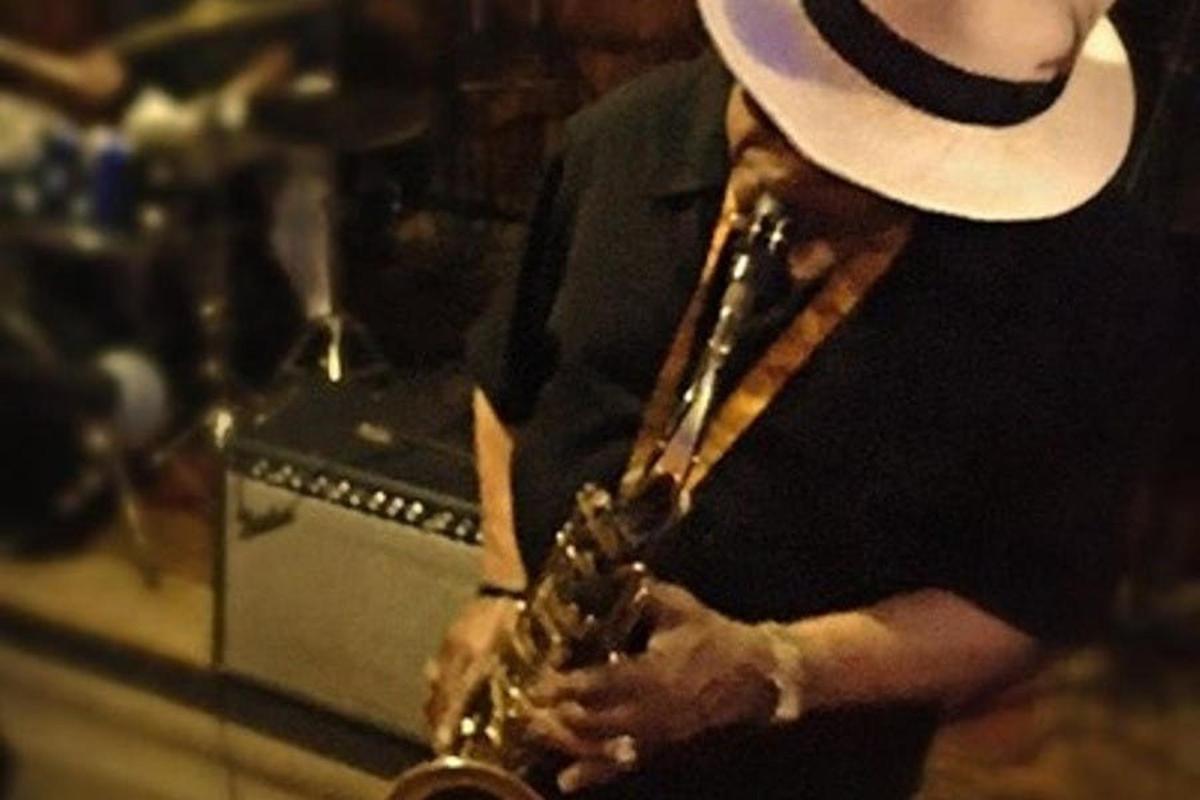 a person wearing a hat holding a saxophone