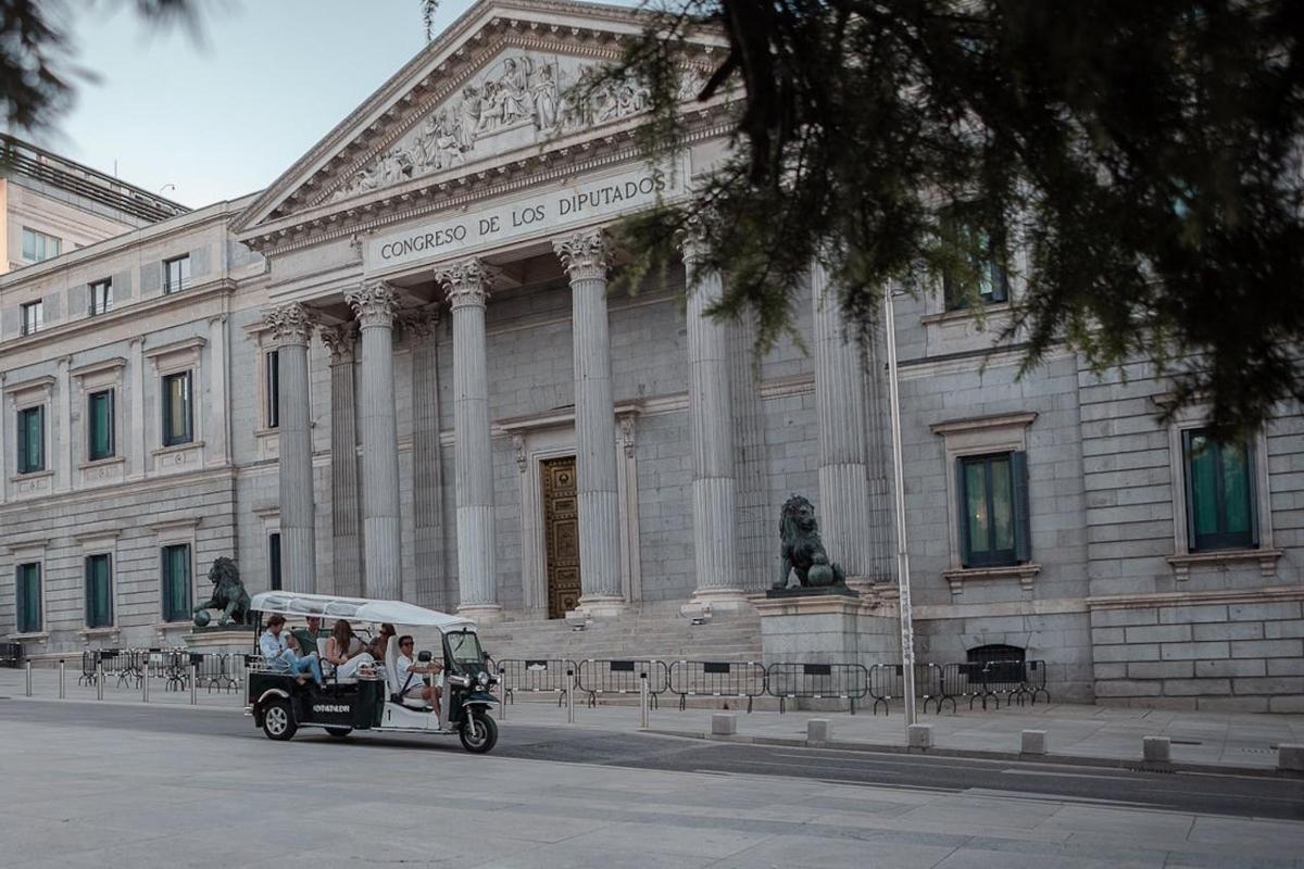μια ομάδα ανθρώπων που επιβαίνουν σε ένα αυτοκίνητο μπροστά από ένα κτίριο