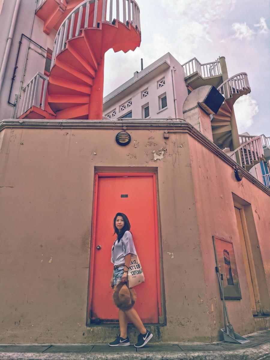 a woman standing in front of a red door