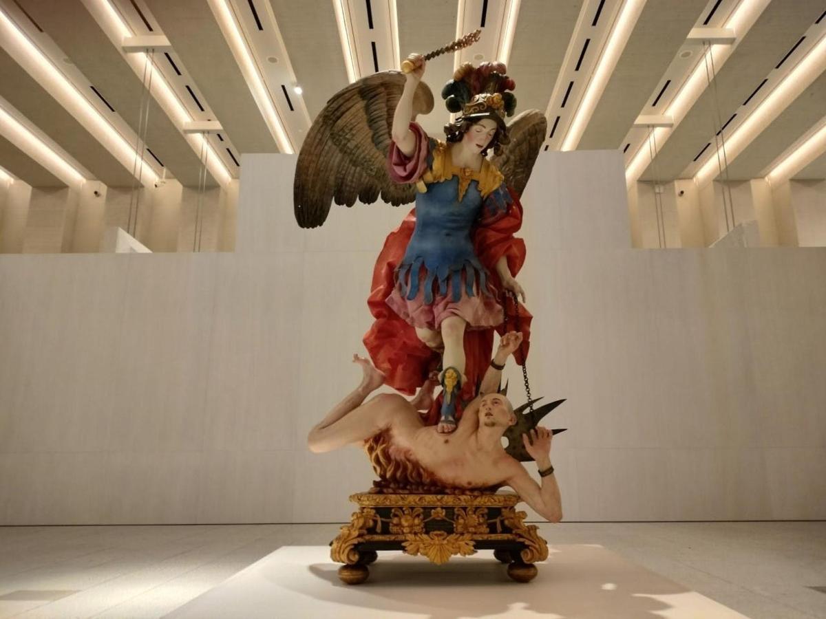 una statua di un angelo su un tavolo in un museo